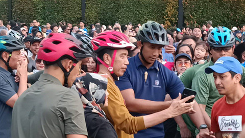 Presiden Joko Widodo bersama Ibu Negara Iriana Joko Widodo dan cucunya Jan Ethes bersepedan saat car free day (CFD) di sekitar Bundaran HI, Jakarta, hari ini, Minggu (9/6/2024). Foto: Zamachsyari/kumparan
