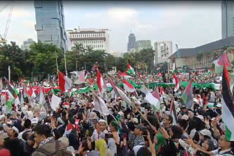 Massa aksi bela Palestina bentangkan bendera Palestina berukuran besar saat aksi bela Palestina di Kawasan Patung Kuda Arjuna Wiwaha, Jakarta Pusat, sore ini, Minggu (9/6/2024). Foto: Zamachsyari/kumparan