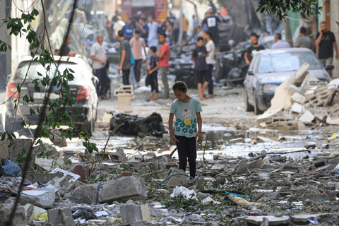 Seorang anak Palestina berjalan di antara puing-puing bangunan yang hancur usai serangan kamp pengungsi Nuseirat di Jalur Gaza tengah, Minggu (9/6/2024). Foto: Eyad BABA / AFP