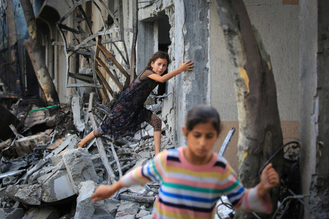 Seorang anak Palestina berjalan di antara puing-puing bangunan yang hancur usai serangan kamp pengungsi Nuseirat di Jalur Gaza tengah, Minggu (9/6/2024). Foto: Eyad BABA / AFP