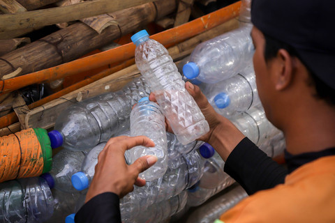 Petugas Unit Penanganan Sampah Badan Air (UPS BA) Dinas Lingkungan Hidup DKI Jakarta Kecamatan Senen memilah limbah botol plastik. Foto: Jamal Ramadhan/kumparan