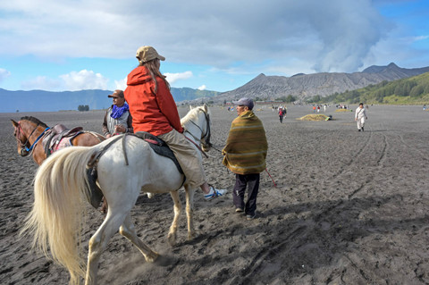 Wisatawan asing menaiki kuda di lautan pasir Gunung Bromo, Probolinggo, Jawa Timur, Kamis (13/6/2024). Foto: Ahmad Subaidi/ANTARA FOTO