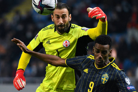 Penyerang Swedia Alexander Isak menantang kiper Georgia George Loria selama pertandingan sepak bola kualifikasi Piala Dunia FIFA Qatar 2022 antara Georgia dan Swedia di Batumi (11/11/2021). Foto: Vano SHLAMOV/AFP