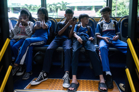 Sejumlah pelajar SMP Negeri 4 Jakarta berada di dalam bus sekolah gratis di Jalan Perwira, Sawah Besar, Jakarta, Jumat (14/6/2024). Foto: Aprillio Akbar/ANTARA FOTO