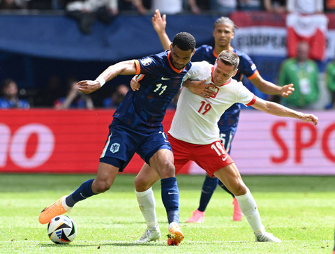 Cody Gakpo dari Belanda beraksi bersama Przemyslaw Frankowski dari Polandia pada Piala Eropa 2024 antara Polandia vs Belanda di Stadion Volkspark, Hamburg, Minggu (16/6/2024). Foto: Annegret Hilse/REUTERS
