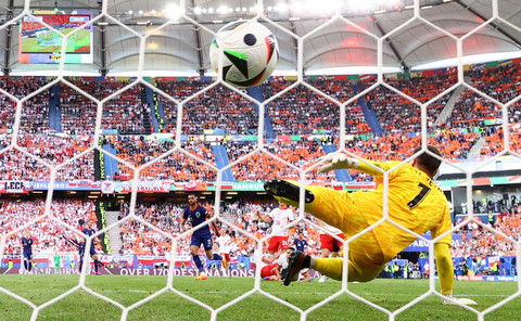 Cody Gakpo dari Belanda mencetak gol pertama mereka melewati pemain Polandia Wojciech Szczesny pada Piala Eropa 2024 antara Polandia vs Belanda di Stadion Volkspark, Hamburg, Minggu (16/6/2024). Foto: Fabian Bimmer / REUTERS
