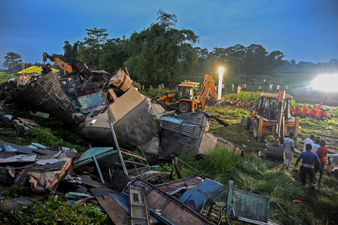 Para pekerja kereta api membantu memulihkan layanan di lokasi kecelakaan setelah tabrakan antara kereta penumpang dan kereta barang di Nirmaljote, dekat stasiun Rangapani di negara bagian Benggala Barat, India (17/6/2024). Foto: Dibyangshu SARKAR/AFP