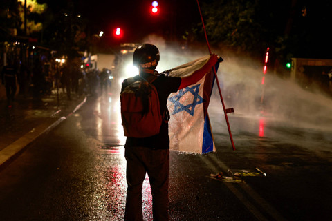 Warga Israel menggelar aksi unjuk rasa yang menyerukan anti-pemerintah di dekat kediaman Perdana Menteri Israel di Yerusalem, Senin (17/5/2024). Foto: Menahem Kahana/AFP