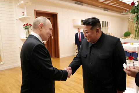 Pemimpin Korea Utara Kim Jong-un berjabat tangan dengan Presiden Rusia Vladimir Putin setibanya di Pyongyang, Korea Utara, Selasa (18/6/2024). Foto: KCNA/via REUTERS