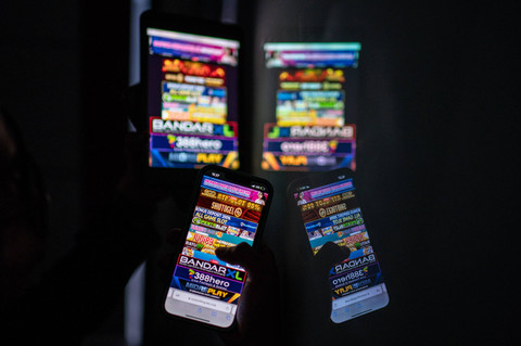 Warga melihat iklan judi online melalui gawainya di Jakarta, Rabu (19/6/2024). Foto: Aprillio Akbar/ANTARA FOTO