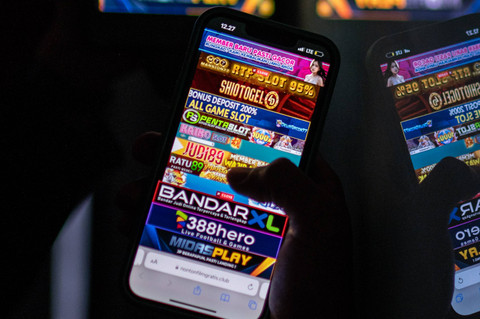 Warga melihat iklan judi online melalui gawainya di Jakarta, Rabu (19/6/2024). Foto: Aprillio Akbar/ANTARA FOTO