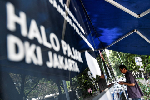 Warga membayar pajak kendaraan bermotor di gerai pelayanan Samsat keliling di Lapangan Banteng, Jakarta, Kamis (20/6/2024). Foto: Hafidz Mubarak A/ANTARA FOTO