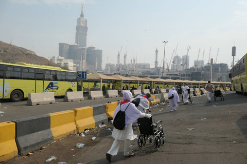 Jamaah haji Indonesia melintas di dekat bus Shalawat di Terminal Syib Amir, Makkah, Arab Saudi, Kamis (20/6/2024). Foto: Sigid Kurniawan/ANTARA FOTO 