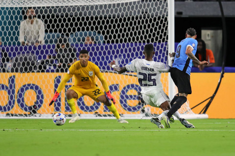 Pemain Uruguay Darwin Nunez menendang bola saat berebut bola dengan pemain Panama Roderick Miller selama pertandingan sepak bola grup C turnamen Copa America Conmebol 2024 antara Uruguay dan Panama di Stadion Hard Rock di Miami, Florida (24/6/2024). Foto: Chris Arjoon/AFP