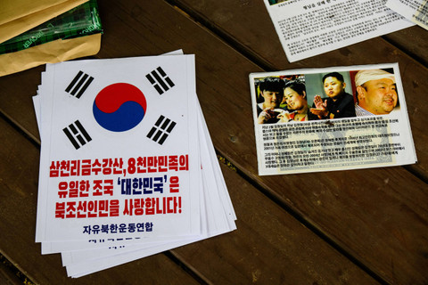 Selebaran (kanan) yang berisi uang kertas dolar AS terlihat di sebelah poster (kiri) bertuliskan "Republik Korea mencintai rakyat Korea Utara" di Seoul, Korea Selatan, Selasa (25/6/2024). Foto: Anthony Wallace/AFP