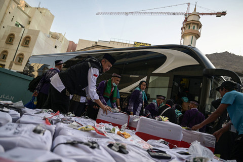 Petugas memeriksa koper jemaah haji Indonesia kloter 12 asal embarkasi Batam yang akan diberangkatkan ke Madinah di Makkah, Arab Saudi, Rabu (26/6/2024). Foto: Sigid Kurniawan/ANTARA FOTO 
