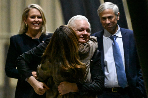 Pendiri WikiLeaks Julian Assange memeluk istrinya Stella Assange setelah tiba di Bandara Canberra, Canberra, Australia, Rabu (26/6/2024). Foto: William WEST / AFP
