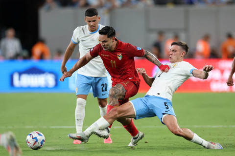 Pemain Bolivia Carmelo Algaranaz berebut bola dengan pemain Uruguay Manuel Ugarte selama pertandingan sepak bola grup C turnamen Copa America 2024 Conmebol 2024 di Stadion MetLife di East Rutherford, New Jersey, pada Kamis (27/6/2024). Foto: Charly Triballeau/AFP