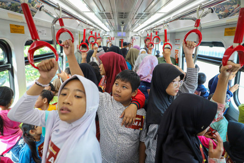 Sejumlah anak-anak dan para pendamping menaiki LRT Jakarta di Stasiun LRT Velodrome, Jakarta, Minggu (30/6/2024). Foto: Iqbal Firdaus/kumparan