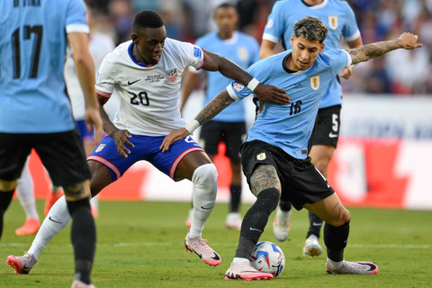Pemain Timnas Amerika Serikat Folarin Balogun berebut bola dengan pemain Timnas Uruguay Mathias Olivera pada pertandingan Grup C Copa America Stadion Arrowhead, Kansas City, Missouri, Amerika Serikat, Selasa (2/7/2024). Foto: Reed Hoffman/AP PHOTO