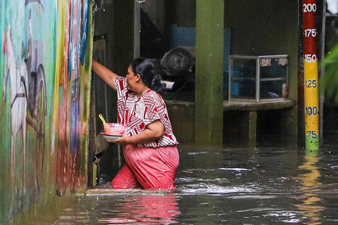 Warga berjalan melintasi banjir di kawasan Kebon Pala, Kampung Melayu, Jakarta, Selasa (2/7/2024). Foto: Iqbal Firdaus/kumparan