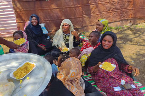 Orang-orang yang melarikan diri dari kota Singa, ibu kota negara bagian Sennar di tenggara Sudan menerima makanan dari Organisasi Independen di sebuah kamp darurat setelah tiba di Gedaref di bagian timur negara yang dilanda perang, Selasa (2/7/2024). Foto: AFP