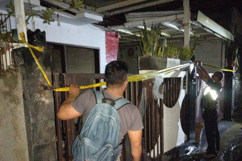 Polisi memasang garis polisi usai kebakaran rumah warga di Bali, Selasa (2/7/2024). Foto: Polresta Denpasar