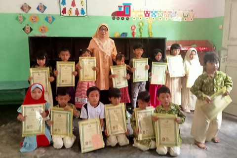 Asniani (tengah) guru taman kanak-kanak (TK) foto bersama bersama muridnya di Desa Sungai Bertam, Kecamatan Jaluko, Kabupaten Muaro Jambi, Jambi Foto: Dok. Istimewa