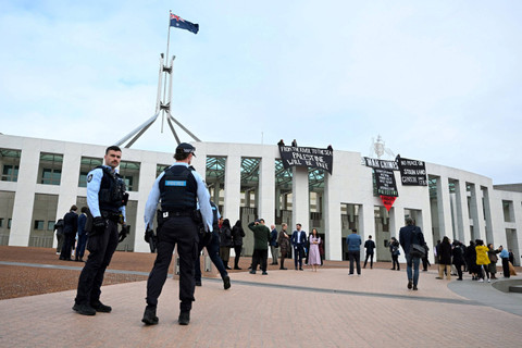 Pengunjuk rasa pro-Palestina menggantung spanduk di puncak Gedung Parlemen di Canberra, Australia, Kamis (4/7/2024). Foto: AAP/Lukas Coch/via REUTERS