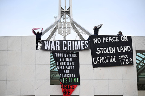 Pengunjuk rasa pro-Palestina menggantung spanduk di puncak Gedung Parlemen di Canberra, Australia, Kamis (4/7/2024). Foto: AAP/Lukas Coch/via REUTERS