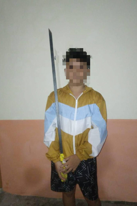 Afif Maulana memegang pedang panjang. Foto ini ditemukan polisi di ponsel Afif. Foto: Dok. Istimewa