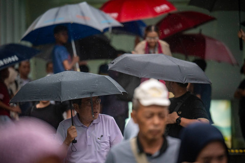 Sejumlah warga menggunakan payung saat turun hujan di kawasan Bundaran HI, Jakarta, Kamis (4/7/2024). Foto: Erlangga Bregas Prakoso/ANTARA FOTO