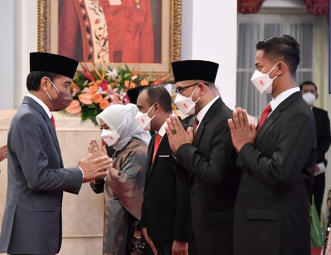Presiden Jokowi beri selamat kepada Hasyim Asy'ari (berpeci) usai pelantikan anggota KPU 2022–2027 di Istana Negara, Jakarta, 12 April 2022. Foto: BPMI Setpres/Lukas