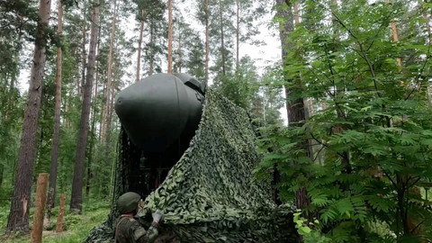 Anggota militer Rusia menutupi sistem rudal balistik antarbenua Yars dengan jaring kamuflase selama latihan di lokasi yang dirahasiakan di Rusia, Jumat (5/7/2024). Foto: Kementerian Pertahanan Rusia/via REUTERS