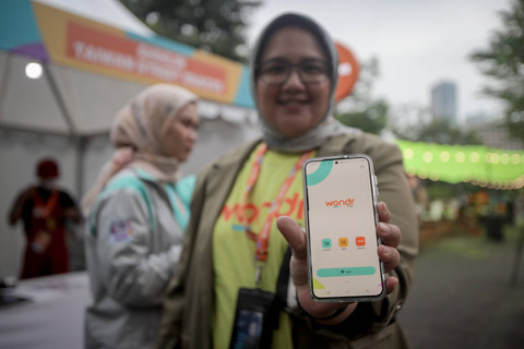 Pengunjung menunjukkan aplikasi m-banking wondr by BNI saat mengunjungi Wondrfest BNI di GBK, Jumat (5/7/2024). Foto: Jamal Ramadhan/kumparan