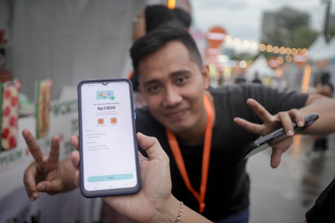 Pengunjung menunjukkan uang yang sudah dibayarkan untuk membeli makanan di Wondrfest BNI di GBK, Jumat (5/7/2024). Foto: Jamal Ramadhan/kumparan