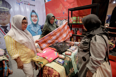 Pengunjung memilih kain saat berkunjung ke Indonesia Maju Expo dan Forum 2024 di Jakarta Convention Center, Jakarta, Sabtu (6/7/2024). Foto: Jamal Ramadhan/kumparan