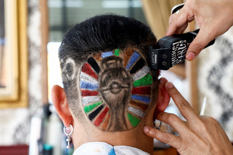 Seorang ahli radiologi medis Mitree Chitinunda (52) sedang dipotong rambut dengan bentuk logo Piala Eropa 2024 di kepalanya di Bangkok Thailand, Sabtu (6/7/2024). Foto: Chalinee Thirasupa/REUTERS