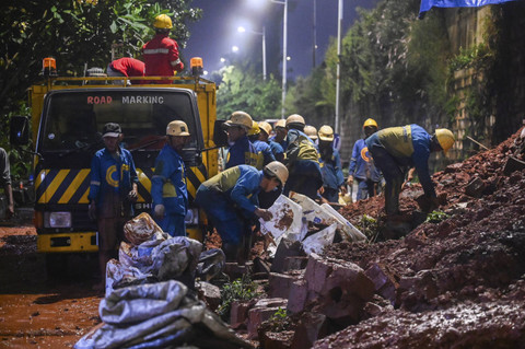 Pekerja membersihkan material longsor tanggul Tol Bintaro, Jakarta, Sabtu (6/7/2024). Foto: Rivan Awal Lingga/ANTARA FOTO
