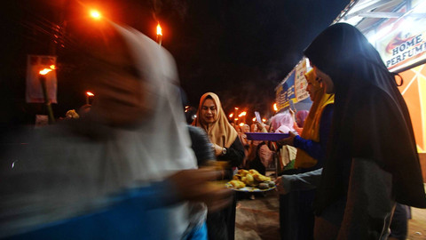 Warga Talang Jambe Palembang yang antusias menyambut peserta pawai obor tahunan yang melintas, Minggu (7/7) Foto: ary priyanto/urban id