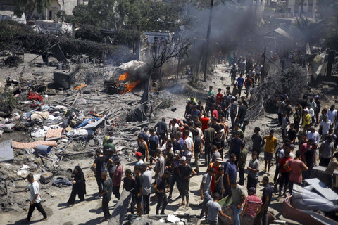 Warga Palestina berkumpul di dekat kerusakan akibat serangan Israel di sebuah tenda pengungsian di daerah Al-Mawasi, Khan Younis di Jalur Gaza selatan, Sabtu (13/7/2024). Foto: Mohammed Salem/Reuters