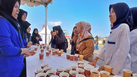 Sejumlah pelajar yang srdang mencoba kopi khas Sumsel dalam pencanangan gerakan minum kopi pinggir Sungai Musi yang tercatat sebagai rekor MURI karena melibatkan 2024 pecinta kopi lokal, Sabtu (13/7) Foto: ary priyanto/urban id
