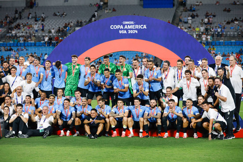 Para pemain Uruguay berpose dengan medali mereka setelah mengalahkan Kanada dalam adu penalti dalam pertandingan perebutan tempat ketiga Copa America di Bank of America Stadium, Minggu (14/7/2024). Foto: Nell Redmond/AP Photo