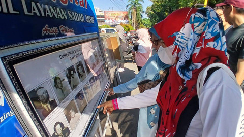 Sejumlah warga yang sedang melihat poto Gubernur Sumsel dari masa ke masa yang merupakan kegiatan edukasi sejarah yang dilakukan Dinas Arsip Daera Provinsi Sumatera Selatan, Minggu (14/7) Foto: ary priyanto/urban id