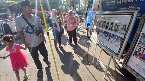 Sejumlah warga yang melintas di depan deretan foto berisi momen sejarah yang merupakan bagian dari program edukasi dinas arsip daerah Sumsel yang dilaksanakan di Taman Kambang Iwak Palembang, Minggu (14/7) Foto: ary priyanto/urban id
