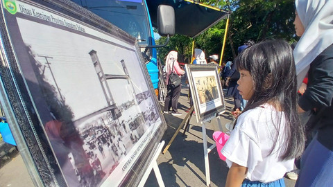 Seorang anak yang menyaksikan sebuah foto yang memuat momen saat jembatan ampera masih beroperasi dengan baik. Kegiatan ini merupakan bentuk edukasi sejarah yang dilakukan dinas arsip daerah Sumsel, Minggu (14/7) Foto: ary priyanto/urban id