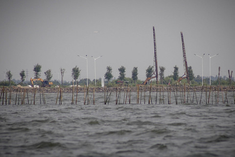 Pagar kayu atau bambu berjejer di perairan di depan lahan yang tengah digarap untuk PSN PIK 2. Foto: Jamal Ramadhan/kumparan