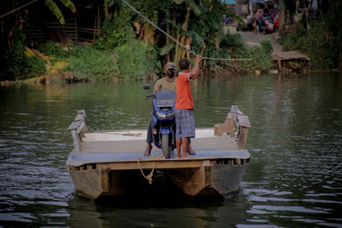 Perahu eretan untuk menyeberangkan warga melintas di Sungai Cisadane, Desa Tanjung Burung, Tangerang. Foto: Jamal Ramadhan/kumparan