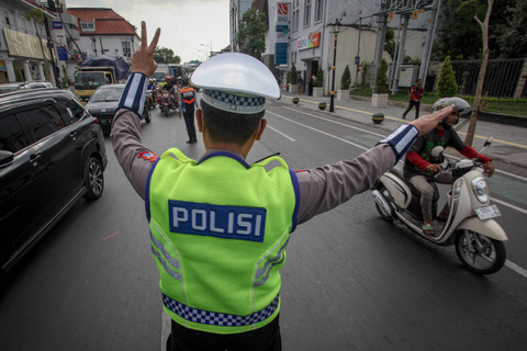 Seorang anggota Satlantas Polrestabes Surabaya mengarahkan pengendara motor saat Operasi Patuh Semeru 2024 di Jalan Rajawali, Surabaya, Jawa Timur, Selasa (16/7/2024). Foto: Didik Suhartono/ANTARA FOTO
