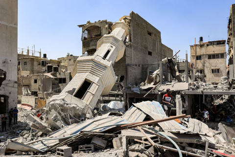Seorang anak berjalan di puing-puing puing-puing bangunan yang hancur di dekat menara masjid yang roboh di Nuseirat, Jalur Gaza, Rabu (17/7/2024). Foto: Eyad BABA / AFP